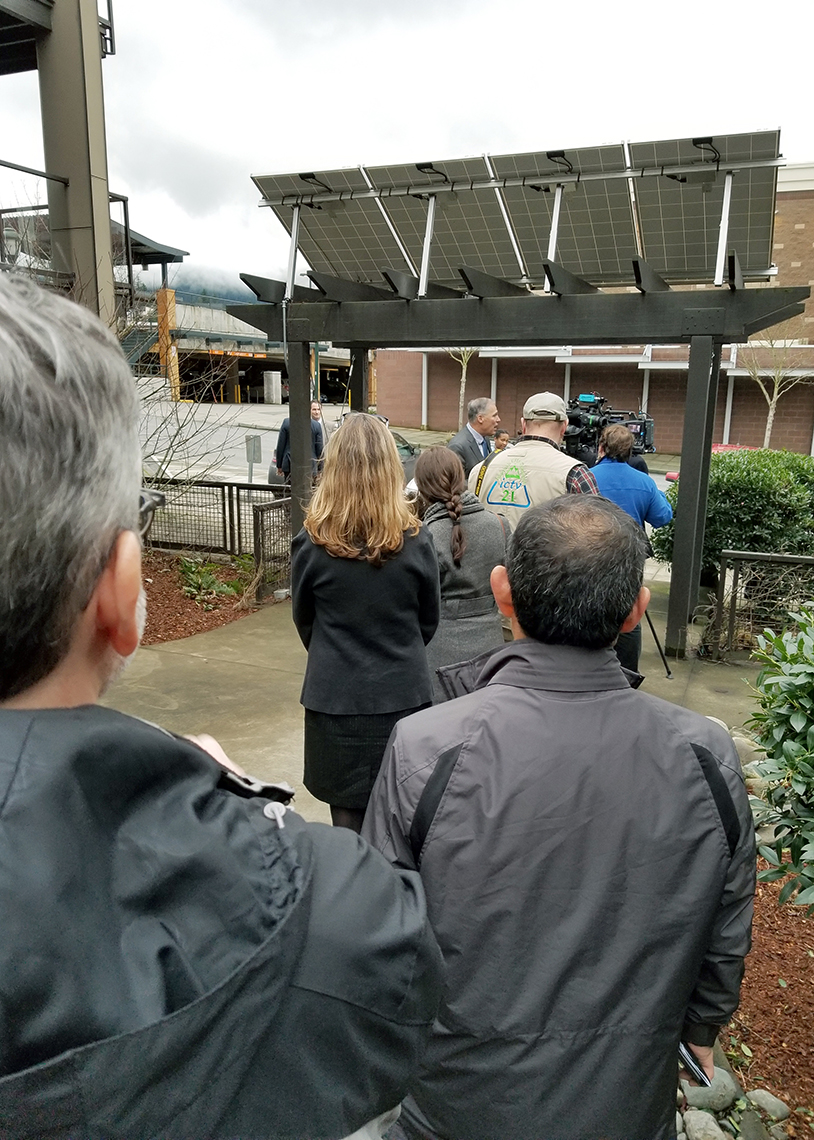 Governor Jay Inslee talks to the media beneath the zHome neighborhood's community solar array